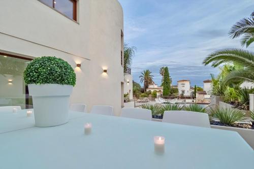 una mesa y sillas blancas con vistas a una casa en Villa N15 en plein cœur de la Marina, proche de Rosas, Costa Brava, en Empuriabrava