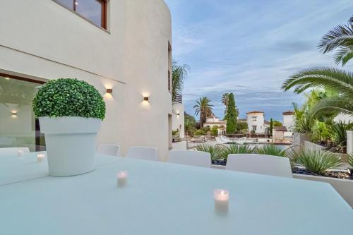 a white table and chairs with a view of a house at Villa N15 en plein cœur de la Marina, proche de Rosas, Costa Brava in Empuriabrava