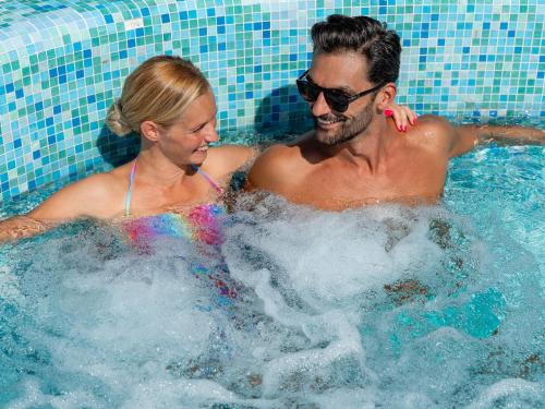 a man and a woman in a swimming pool at Active Hotel Paradiso in Peschiera del Garda