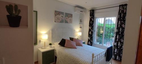 a bedroom with a white bed and a window at Casas-VeraPlaya Al Andalus Residencial Casa La Libertad in Vera