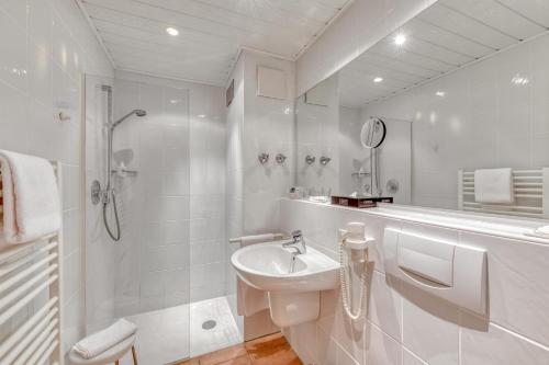 
a white bath tub sitting next to a white sink at Hotel Alt Vellern in Beckum
