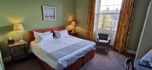 a bedroom with a large bed and a window at Buccleuch and Queensberry Arms Hotel in Thornhill
