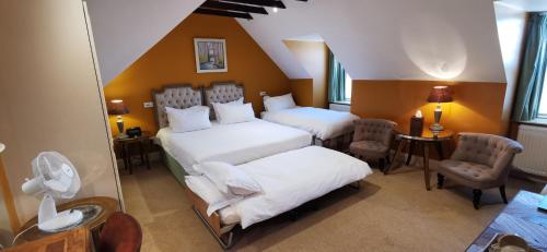 a bedroom with two beds and a table and chairs at Buccleuch and Queensberry Arms Hotel in Thornhill