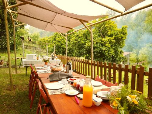Couto的住宿－Verde Água Agroturismo e Agricultura Biológica，一张带食物盘子和雨伞的木桌