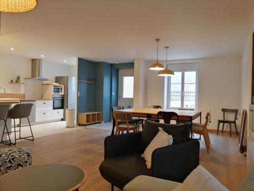 een woonkamer en een keuken met een bank en een tafel bij Les Briquettes in Mailly-Champagne
