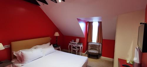 a red bedroom with a white bed and a window at Buccleuch and Queensberry Arms Hotel in Thornhill