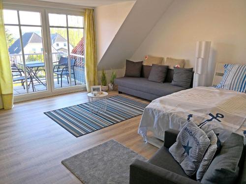 ein Wohnzimmer mit einem Bett und einem Sofa in der Unterkunft Ferienwohnung Utkiek - Ruhe und Erholung in Heringsdorf