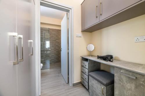 a bathroom with a counter with a sink and a shower at Villa Olivia in Xylophaghou