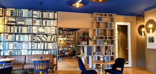 a room with a large library with tables and chairs at Pension Zeitlos in Potsdam