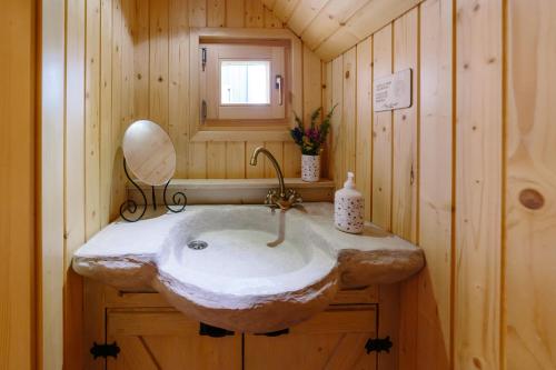 a bathroom with a stone sink in a log cabin at Chalet Orlica Velika Planina in Stahovica