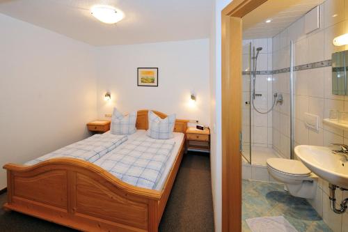 a bedroom with a bed and a shower and a sink at Ferienwohnung Vogl in Berchtesgaden