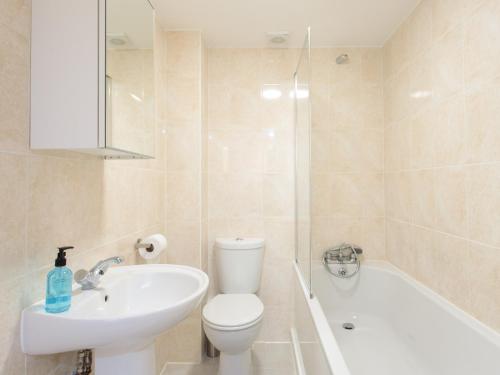 La salle de bains est pourvue de toilettes, d'un lavabo et d'une baignoire. dans l'établissement Dartford Luxurious Apartment, à Dartford
