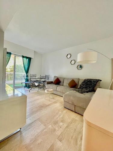 a living room with a couch and a table at Résidence standing Rivièra Golf Mandelieu in Mandelieu-la-Napoule