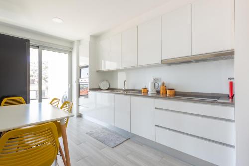 a kitchen with white cabinets and a table and chairs at Getaway to Blue Paradise at Madeira Island in Funchal