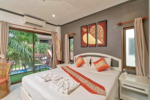 a bedroom with a bed and a balcony at Sai Rougn Residence - SHA Extra Plus in Patong Beach