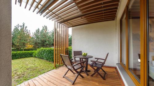 a patio with a table and chairs on a deck at Olympic Park I, Sun & Snow in Kołobrzeg