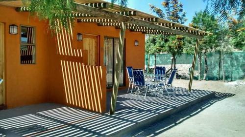 a patio with blue chairs and a house at Cabañas Stommeln in Ovalle