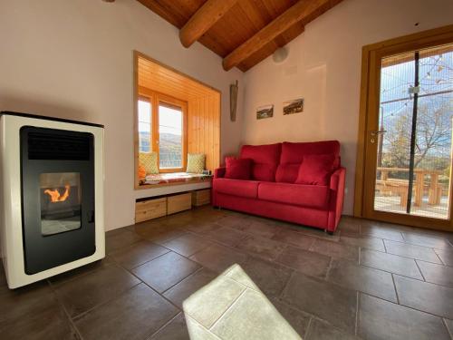 a living room with a red couch and a fireplace at Caseta de Magí in Ager