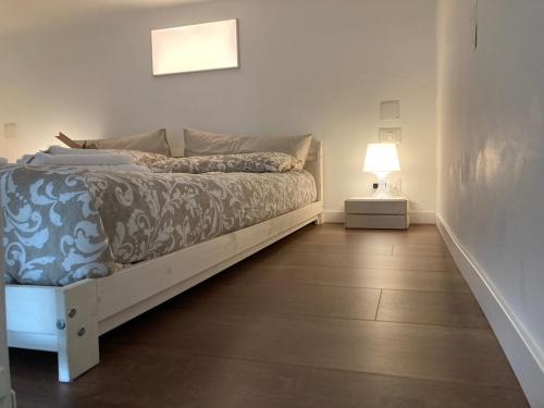 - une chambre avec un lit et une lampe sur du parquet dans l'établissement White flat Puglie, à Milan