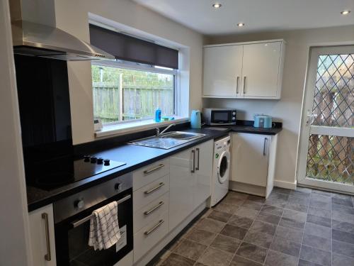 a kitchen with a sink and a stove top oven at Warsett Crescent, 5 bedrooms near the coast. in Skelton