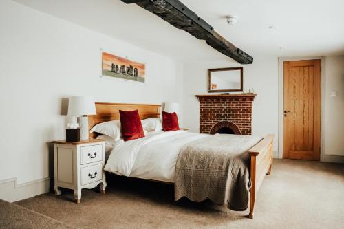 a bedroom with a large bed and a fireplace at The Peppermill Town house Hotel & Restaurant in Devizes