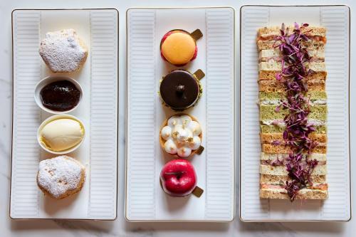 four white plates with different types of food on them at The Parkgate Hotel in Cardiff