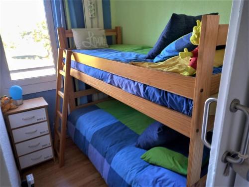 two bunk beds in a room with a window at Coqueto apartamento en Osseja in Osséja