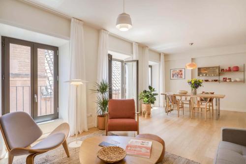 a living room with a table and a dining room at Solaga - Larios Suites in Málaga