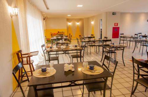 une salle à manger avec des tables et des chaises dans un restaurant dans l'établissement Pousada Serra Bella, à Tianguá