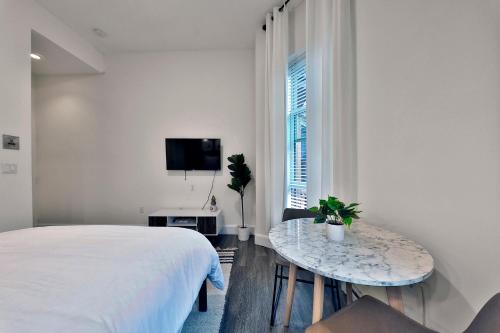 a bedroom with a bed and a table and a tv at Good Hotels Boston in Boston
