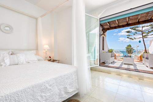 sypialnia z łóżkiem i dużym oknem w obiekcie Noemi Playa Beach House in Malaga by Solaga Holiday Homes w Maladze