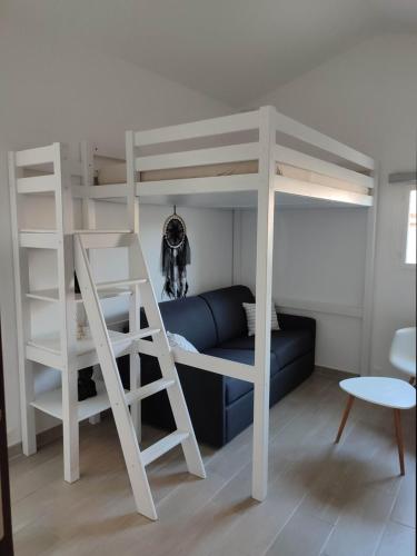 1 dormitorio con litera y sofá azul en F1 avec un espace jardin, en Gattières