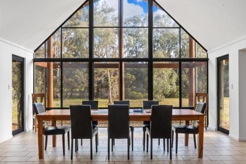 a dining room with a table and chairs and a large window at Kangaroo Retreat - Family Favourite Bush Retreat with Kangaroos in Margaret River in Margaret River Town
