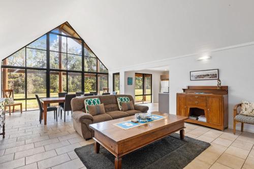 a living room with a couch and a table and a piano at Kangaroo Retreat - Family Favourite Bush Retreat with Kangaroos in Margaret River in Margaret River Town
