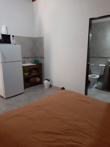 a room with a white refrigerator and a kitchen at Cabañas Corazon de Maria in Merlo