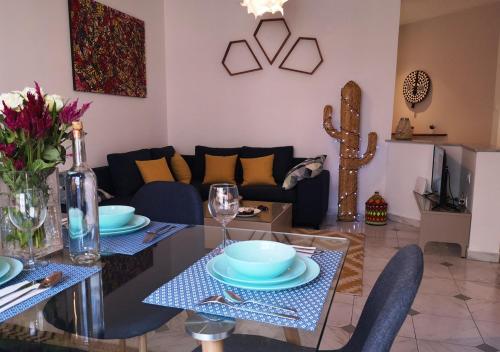 sala de estar con mesa y sofá en LAU 08 Appart Agdal 80m2, en Rabat