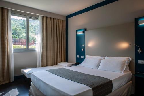 a hotel room with a bed and a window at La Meridiana Bleisure Hotel in Perugia