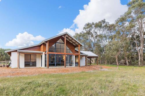 a home with a gambrel roof and glass windows at Kangaroo Retreat - Family Favourite Bush Retreat with Kangaroos in Margaret River in Margaret River Town