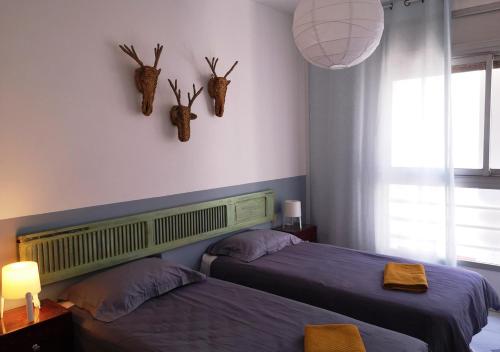 a bedroom with two beds and antlers on the wall at LAU 08 Appart Agdal 80m2 in Rabat