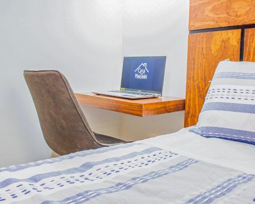 a laptop computer sitting on a desk next to a bed at Casa Mariano in Morelia
