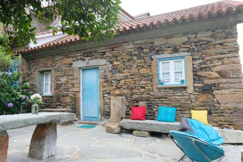 a stone house with a bench and a blue door at Casa do Engenho - Canadelo Amarante in Amarante
