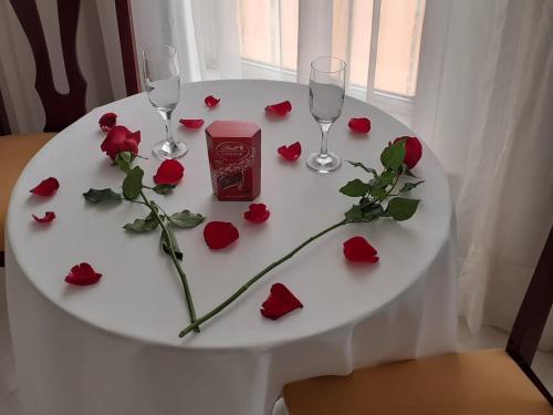 a white table with red roses and wine glasses at Pampas Palace Hotel in São Bernardo do Campo