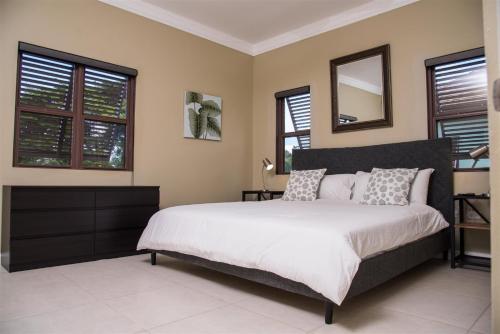 1 dormitorio con 1 cama grande y espejo en Sun-kissed Villa #3 en Mammee Bay