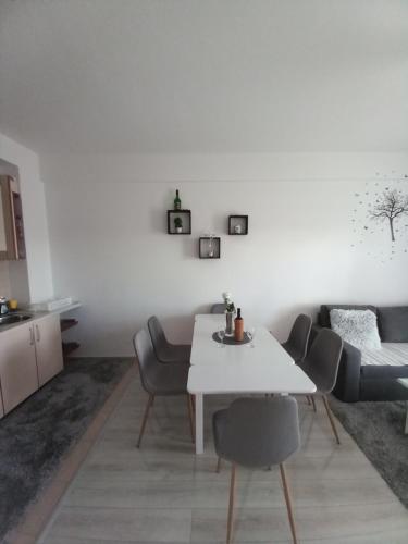 a white dining room with a white table and chairs at Apartman Panorama in Kupres