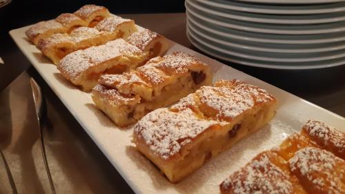 a plate of pastries with powdered sugar on it at Margun - Apartments & PanoramaRooms in Malles Venosta