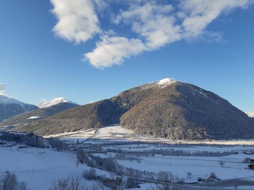 a mountain with snow on it in the foreground at Margun - Apartments & PanoramaRooms in Malles Venosta