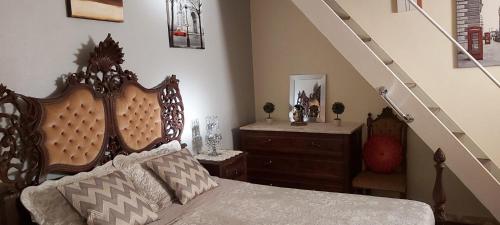 1 dormitorio con 1 cama con cabecero de madera y escalera en CASA RIBEIRINHO No Coração da Natureza, en Pedregal