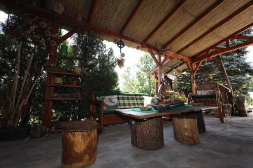 a wooden pavilion with a table and a bench at Etno kuća Teodora in Staji°evo
