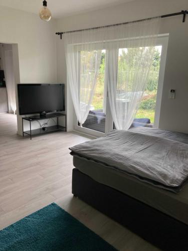 a bedroom with a large bed and a large window at Forststrasse Apartment in Stockstadt am Main