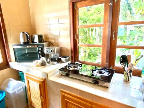 a small kitchen with a stove and a window at Hin Kong Sunset Beach Front House in Srithanu